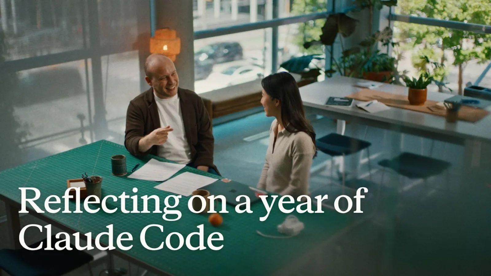 Two Anthropic team members talking across a table in the 'Reflecting on a year of Claude Code' video